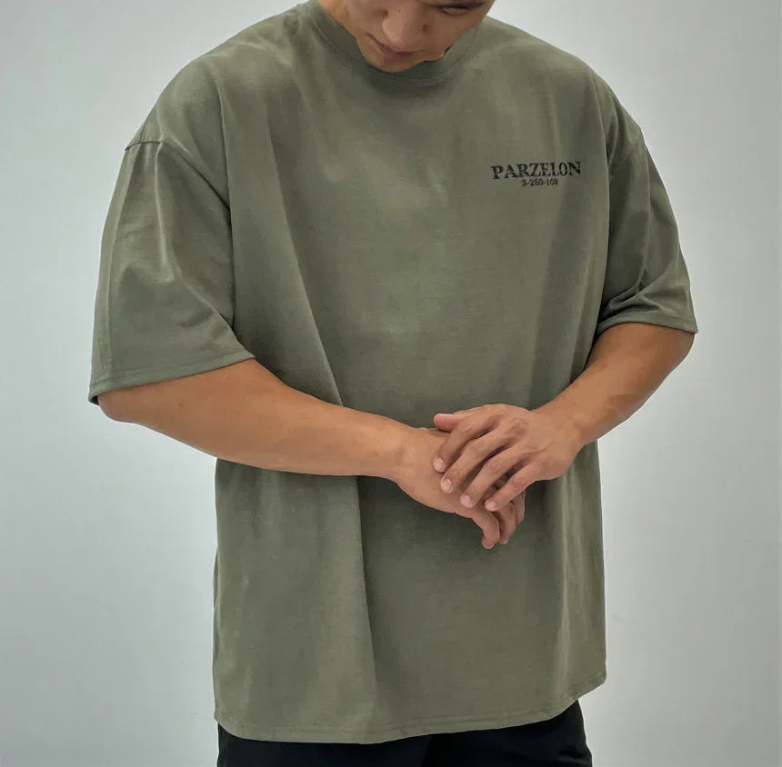 Person wearing a green t-shirt with 'PARZEL' branding on a plain background