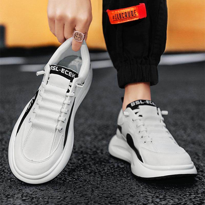 White sneakers with black accents worn by a person on a blurred background