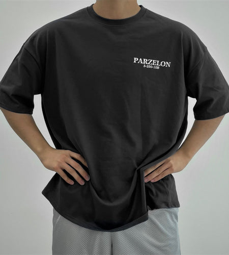 Person wearing a black t-shirt with 'PARZELON' branding on a plain background