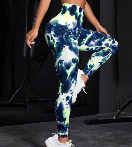 Person wearing tie-dye leggings with a black background