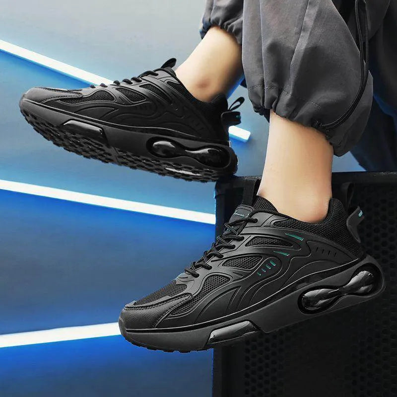 Black athletic shoes worn by a person on a blue background