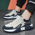 Sneakers with a mix of white, navy, and gray colors on a textured surface.