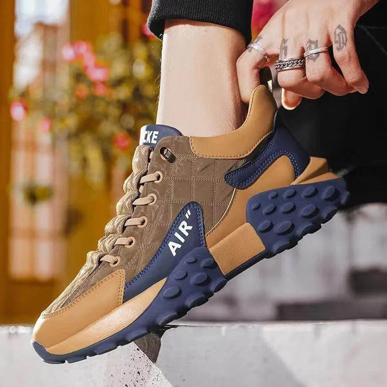 Brown and blue sneakers with 'Nike' branding held by a person.