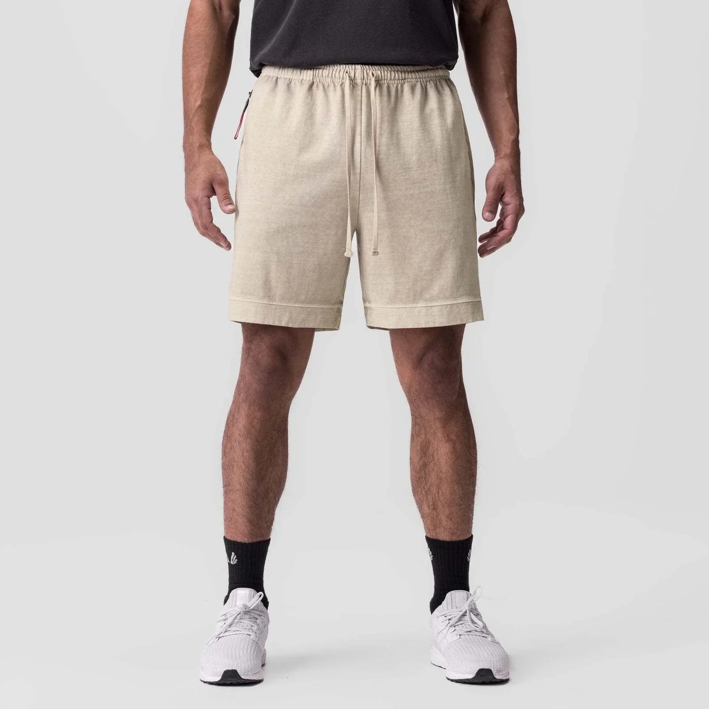 Person wearing beige shorts on a white background