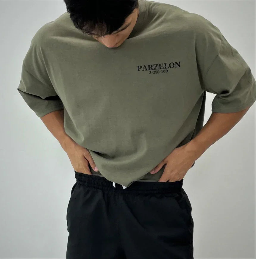 Person wearing a green t-shirt with 'PARZELON' branding on a plain background
