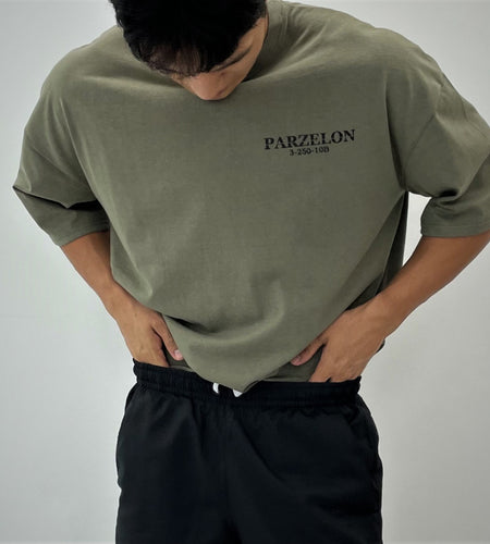 Person wearing a green t-shirt with 'PARZELON' branding on a plain background