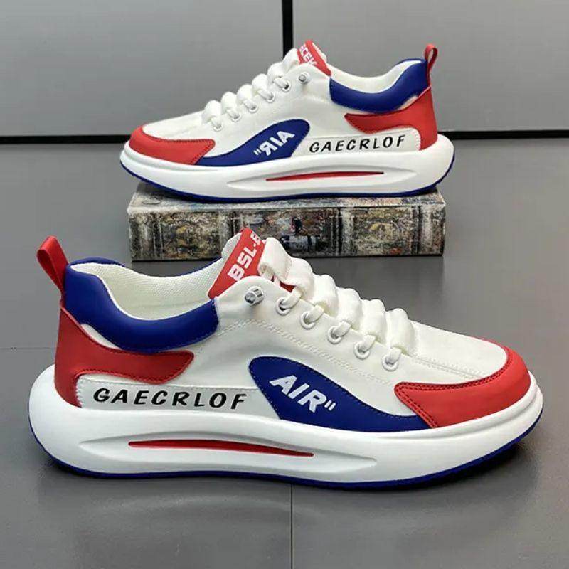 White sneakers with red and blue accents on a gray surface