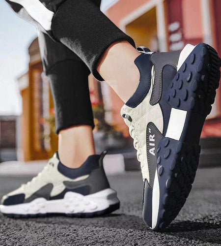 Close-up of black and white sneakers with 'Air' branding on a blurred street background
