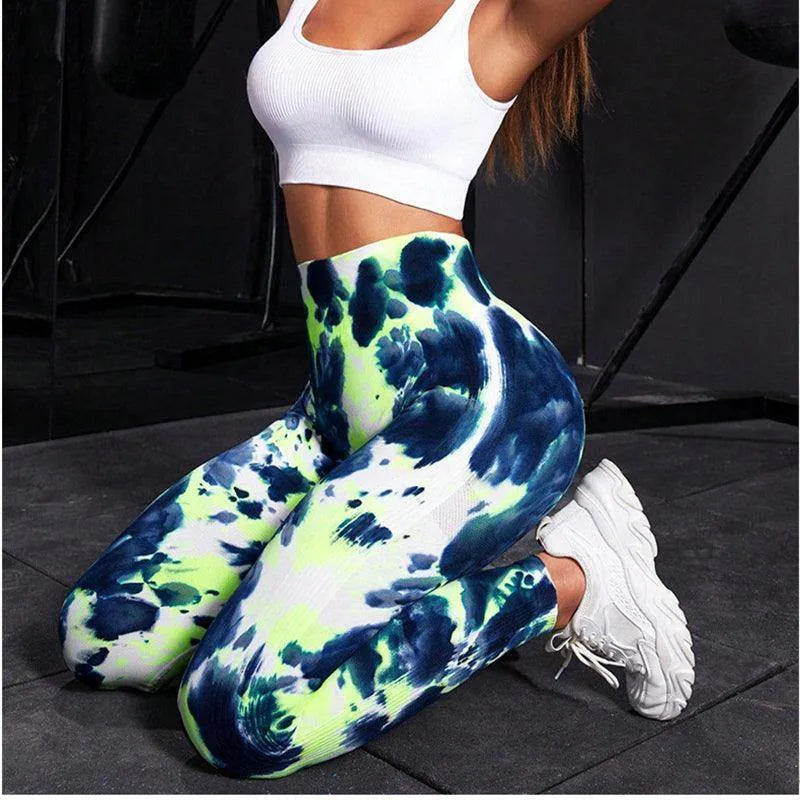 Person wearing blue and green tie-dye socks with a white background