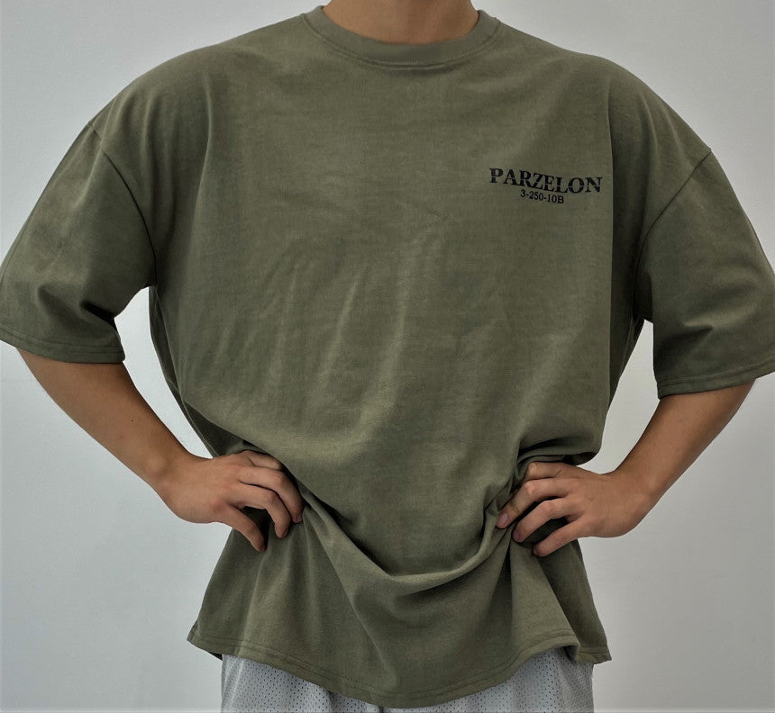 Person wearing a green t-shirt with 'PARZELON' branding on a plain background