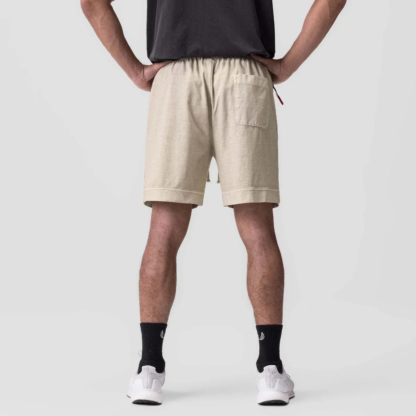 Person wearing beige shorts on a plain background
