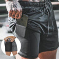 Black athletic shorts with a pocket holding a phone, worn by a person.
